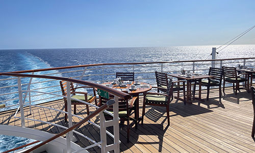Tische im Außenbereich mit Blick auf Meer im Restaurant Marketplace