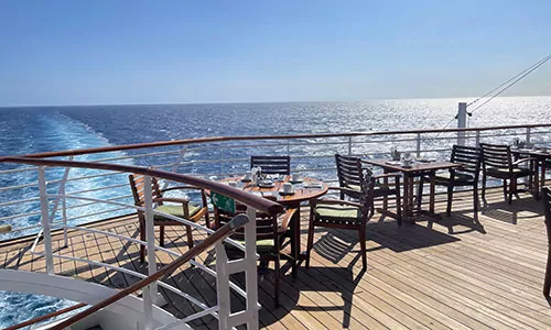 Tische im Außenbereich mit Blick auf Meer im Restaurant Marketplace