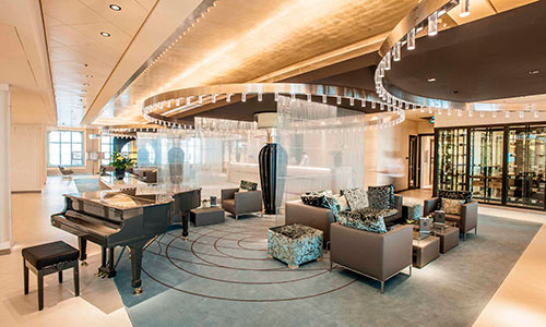 Atrium mit Klavier und Sitzbereich auf dem Kreuzfahrtschiff MS Europa 2