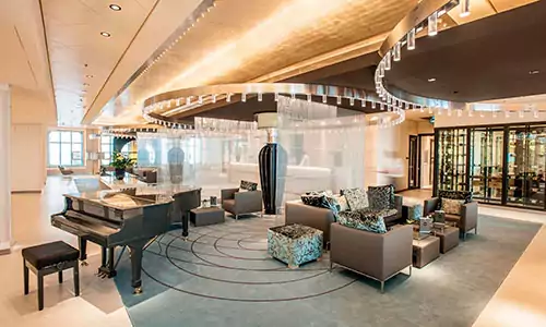 Atrium mit Klavier und Sitzbereich auf dem Kreuzfahrtschiff MS Europa 2