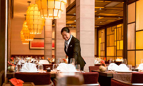 Servicekraft beim Tisch dekorieren im Restaurant Elements auf dem Kreuzfahrtschiff MS Europa 2