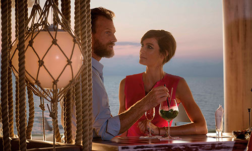 Gäste an der Bar im Hintergrund Meer in der Sansibar