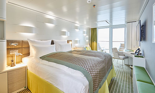 Schlafbereich mit Blick auf Balkon der Balkonkabine auf dem Luxus-Expeditionsschiff Hanseatic spirit von HL-Cruises