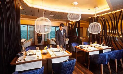 Kellner beim Service im Restaurant Hamptons auf dem Luxus-Expeditionsschiff Hanseatic spirit von HL-Cruises