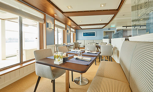 Tische am Panoramafenster im Restaurant Lido auf dem Luxus-Expeditionsschiff Hanseatic spirit von HL-Cruises