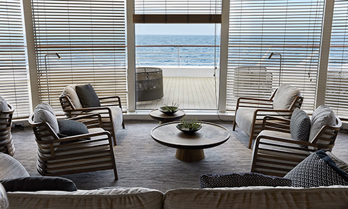 Sitzgruppe und Blick aufs Meer in der Panorama Lounge auf dem Expeditionskreuzfahrtschiff Le Bougainville