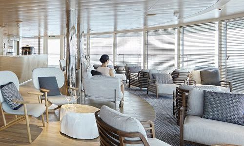 Gast in der Panorama Lounge auf dem Luxus Expeditionsschiff La Champlain