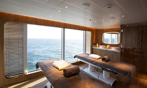 Massageliegen im Spa mit Panoramafenster auf dem Luxusexpeditionsschiff Le Laperouse der Reederei Ponant