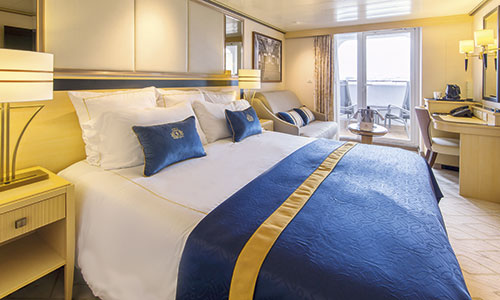 Kingsizebett und Blick auf Sitzbereich und Loggia