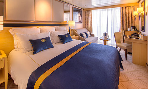 Britannia Club Balkony Kabine Bett und Sitzbereich mit Blick auf Balkon