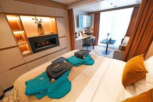 Blick in Balkonsuite mit Bett und Ausstattung mit Rucksack und Jacke für jeden Gast