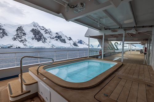 Jacuzzi und Blick auf Küste und verschneite Berge