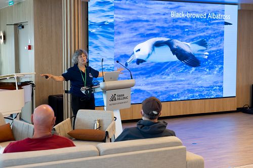 Vortrag einer Lektorin und grosse Display Wand