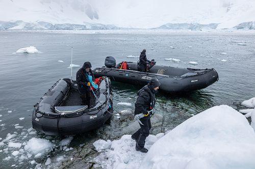 zwei Zodiaks und Crew Mitglieder beim Anlanden auf Eis
