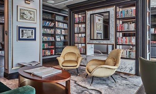 Bibliothek mit Tisch und Sesseln