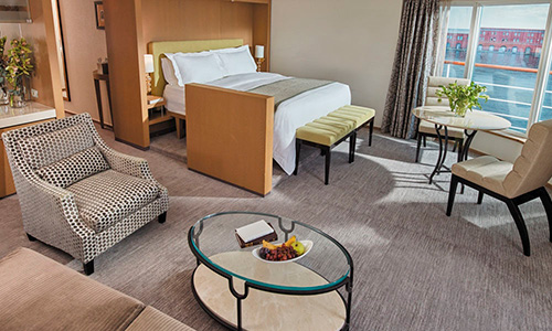 Wohn- und Schlafbereich mit Blick auf Veranda deer Sevens Seas Suite After auf dem Luxuskreuzfahrtschiff Regent Seven Seas Voyager