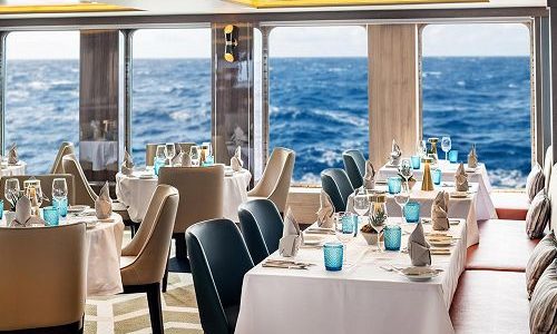 Gedeckte Tische im Restaurant mit Blick aufs Meer