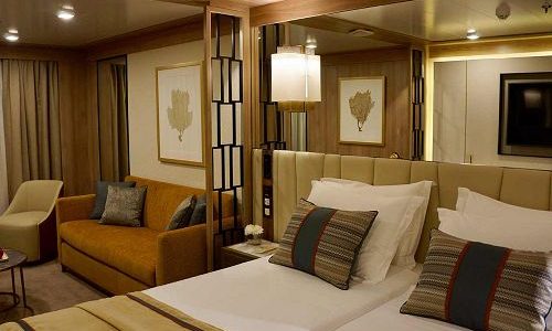 Bett und Sofa in einer Kabine auf dem Expeditionsschiff World Explorer von nicko cruises