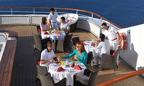 Gäste auf der Terrasse des Grill Restaurants auf der Luxuskreuzfahrtyacht L'Austral der Reederei Ponant