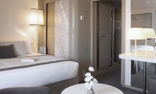 Schlafbereich und Schminktisch in der Deluxe Suite auf der Luxuskreuzfahrtyacht Le Soleal der Reederei Ponant