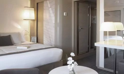 Schlafbereich und Schminktisch in der Deluxe Suite auf der Luxuskreuzfahrtyacht Le Soleal der Reederei Ponant