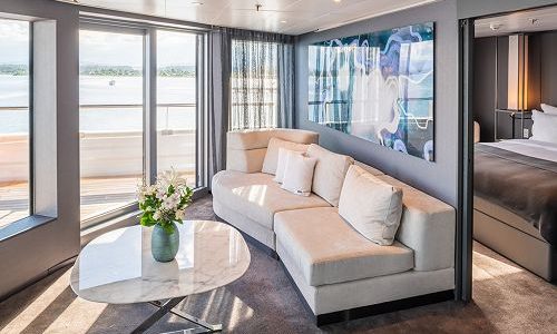 Wohnbereich mit Blick in Schlafzimmer in der Panorama Suite auf dem Luxuskreuzfahrtschiff Scenic Eclipse