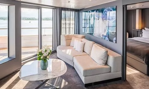 Wohnbereich mit Blick in Schlafzimmer in der Panorama Suite auf dem Luxuskreuzfahrtschiff Scenic Eclipse