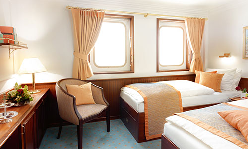 Kabine mit 2 Betten und Sessel auf der Windjammer Sea Cloud