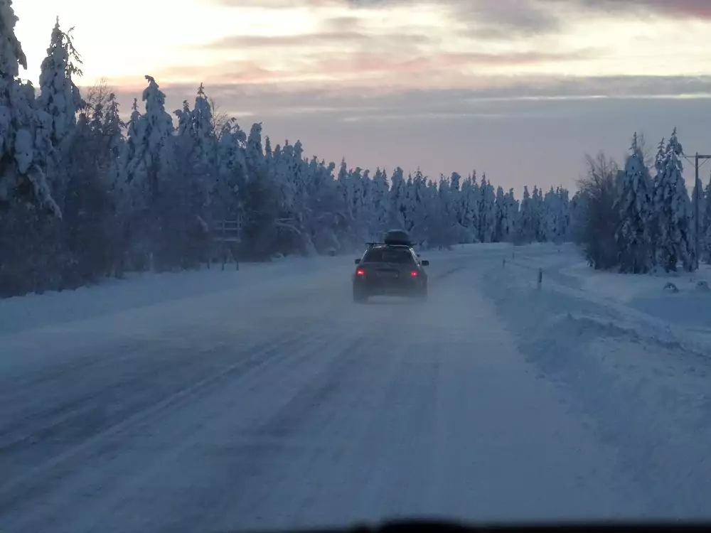 Auto auf winterlicher Straße in Finnland